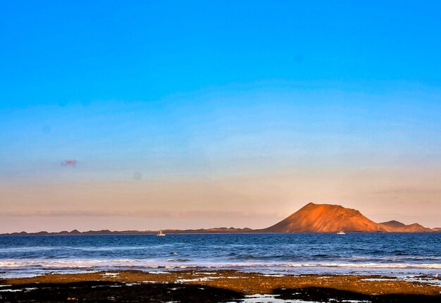 日没時に丘に囲まれた海の美しい風景