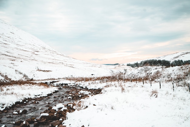 Beautiful scenery of white hills and forests in the countryside during winter