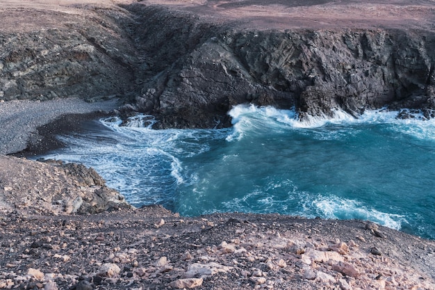 Foto gratuita bella insenatura di mare con acqua che si infrange sulla costa