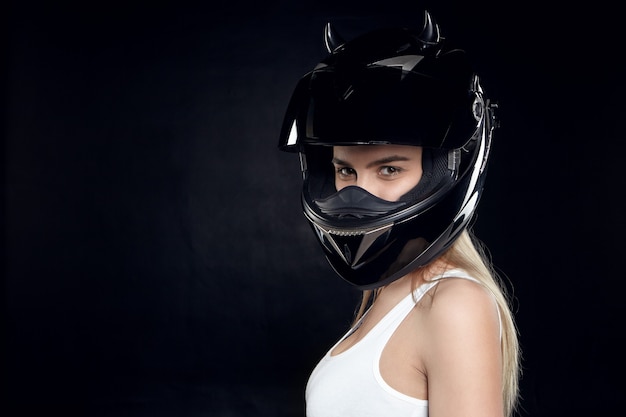 Beautiful self determined young European woman motorcyclist wearing white tank top