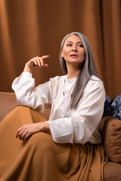 Free photo beautiful senior woman portrait posing on couch