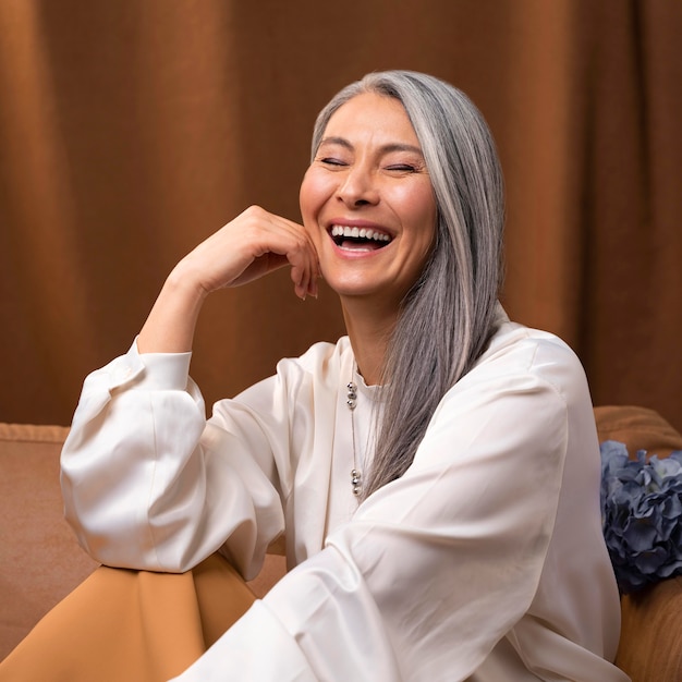 Free photo beautiful senior woman portrait posing on couch