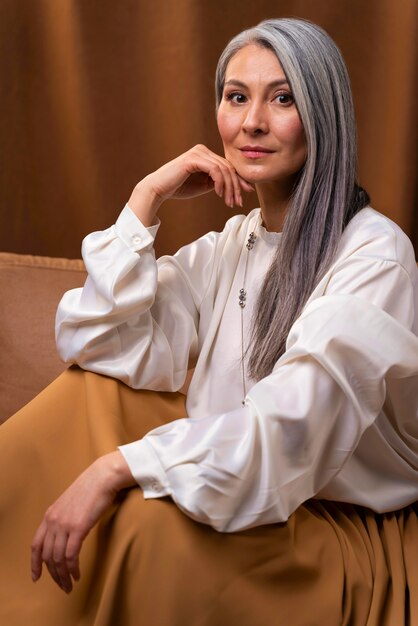 Beautiful senior woman portrait posing on couch