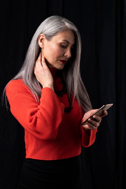 Beautiful senior woman portrait using mobile