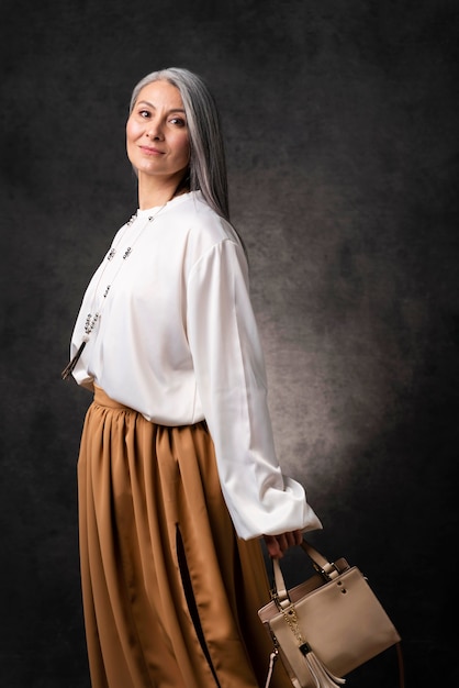 Foto gratuita bello ritratto senior della donna con la borsa a mano