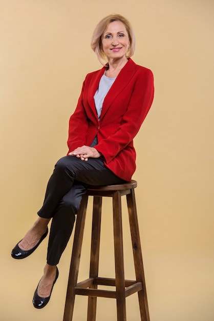 Free photo beautiful senior woman posing on chair