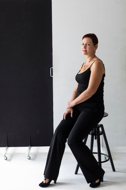 Beautiful senior woman sitting on a stool