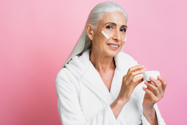 Beautiful senior woman testing cream