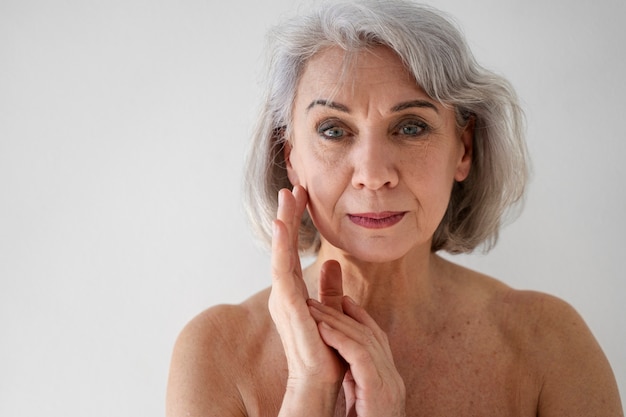 Foto gratuita colpo medio d'uso di trucco della bella donna senior