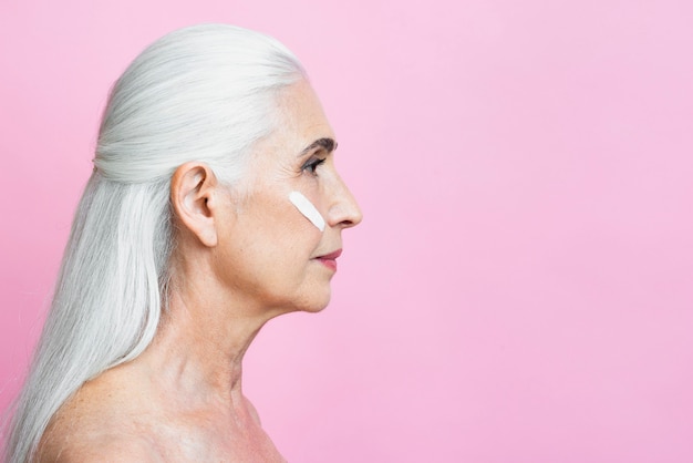 Beautiful senior woman with pink background