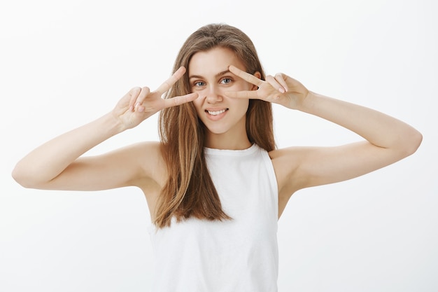 Beautiful sensual blond girl smiling and showing peace gesture