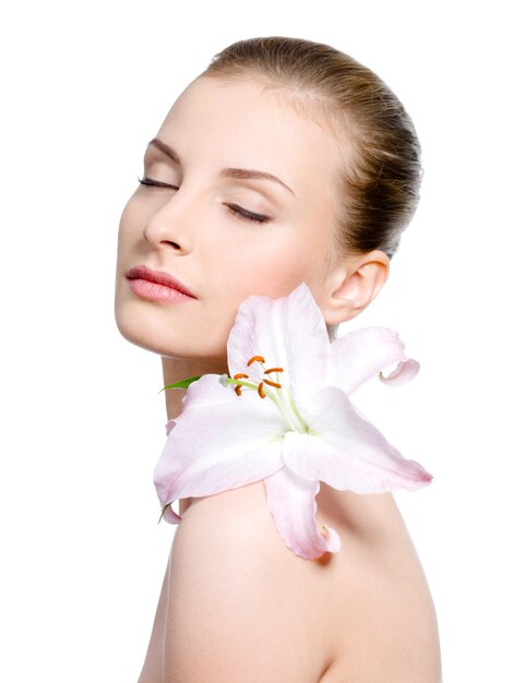 Beautiful sensuality young woman with flower on a shoulder with closed eyes - isolated