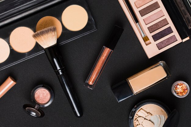 Beautiful set of professional makeup cosmetics on dark table