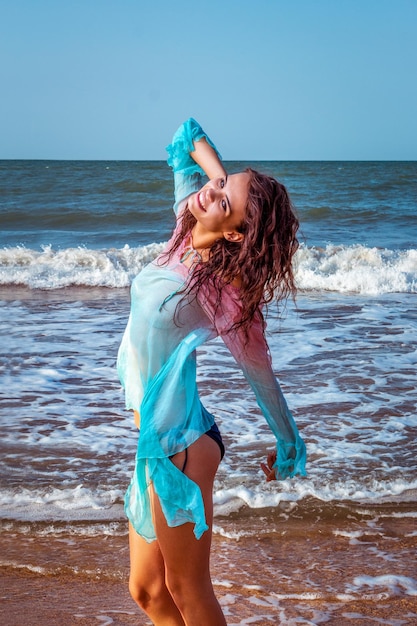 모래 해변에서 포즈를 취하는 수영복에 아름 다운 섹시 한 금발 소녀