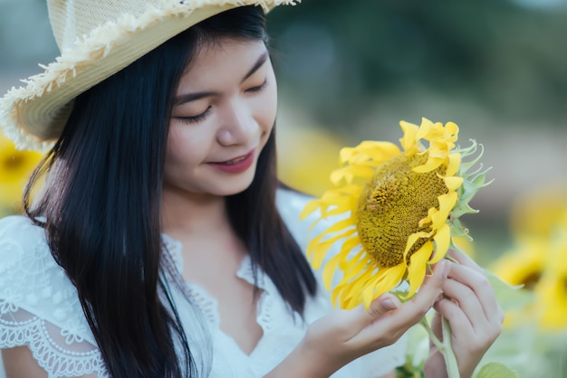 해바라기의 필드에 걷고 하얀 드레스를 입고 아름다운 섹시한 여자