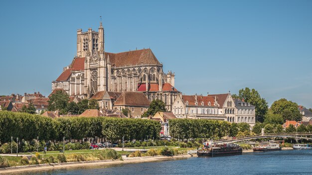 Beautiful shot of the Auxerre Cathedral near the Yonne river on a sunny afternoon in France