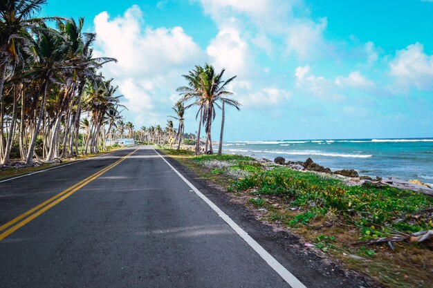 Beautiful shot of a beach road with a cloudy blue sky in the background