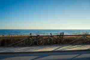 Foto gratuita bellissimo colpo di biciclette vicino a una strada deserta con il mare sullo sfondo