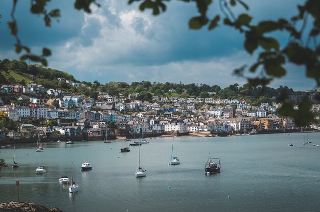 Beautiful shot of boats on the beach close to the city on the hill