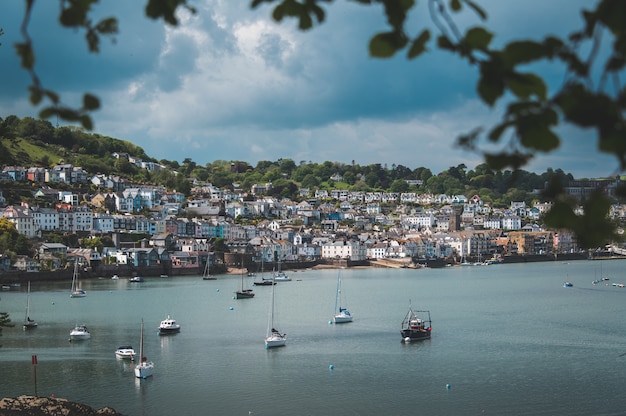 Beautiful shot of boats on the beach close to the city on the hill