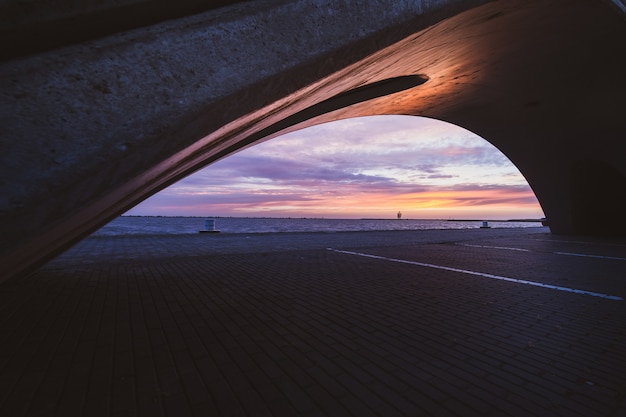 Beautiful shot of a bridge on a reflective lake during the sunset