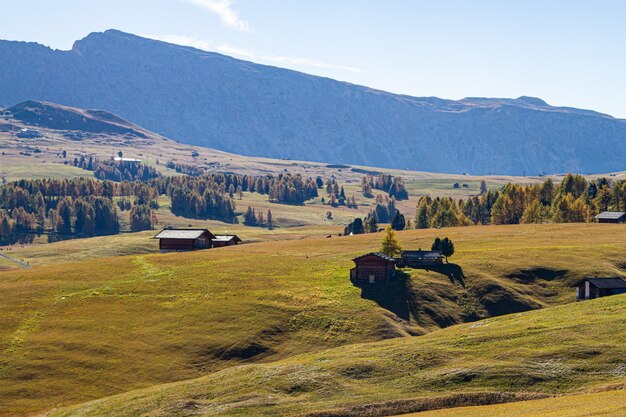 Beautiful shot of buildings on a grassy hill at dolomite Italy