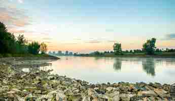 Free photo beautiful shot of a calm lake surrounded by trees during a sunset