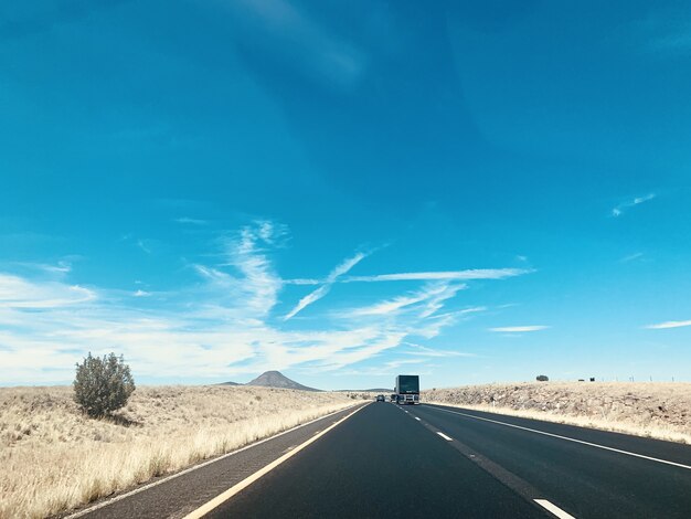 Beautiful shot of the cars on the road under the blue sky