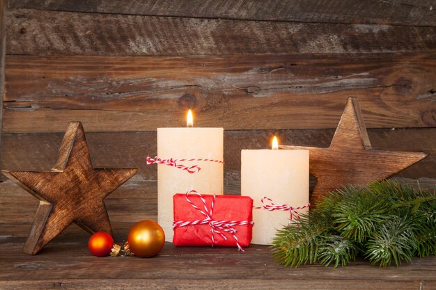 Beautiful shot of Christmas decorations and candles burning on a wooden background