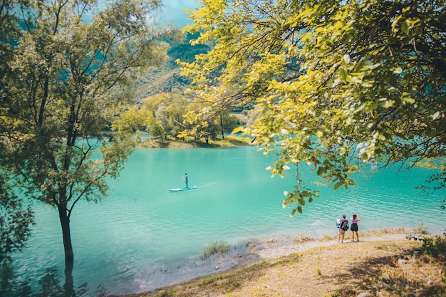 緑に覆われた丘や山々に囲まれた澄んだ湖の美しいショット