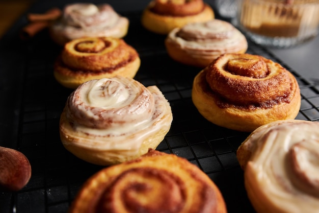 Beautiful shot of delicious Cinnamon Rolls with White Glaze on a black table