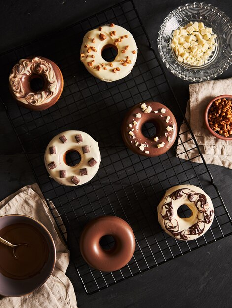 Beautiful shot of delicious donuts covered in the chocolate glaze with the ingredients  on a table