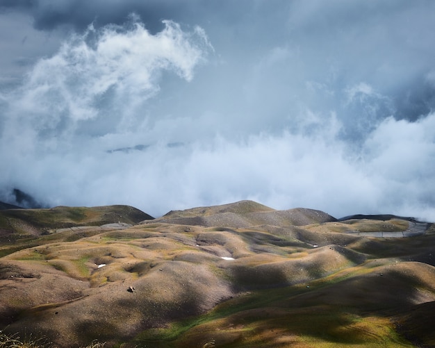 Empty grassy hills under a blue cloudy sky – Free Stock Photo Download