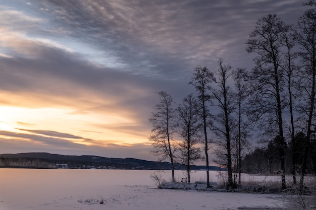 Beautiful shot of a  frozen lake with a scenery of sunset in the sky