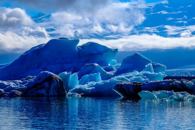 Foto gratuita bello colpo di un ghiacciaio nell'acqua sotto un cielo nuvoloso