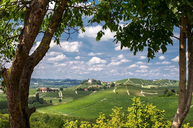 Beautiful shot of green hills and buildings in the distance under a blue cloudy sky