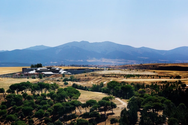 Beautiful shot of green and yellow valley with mountains in the background in Segovia, Spain