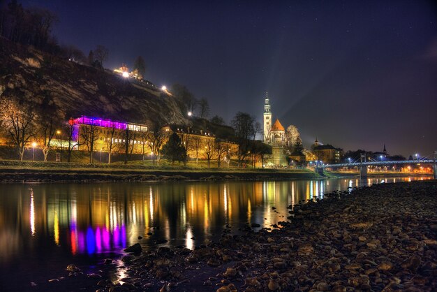 Beautiful shot of the historic city of Salzburg reflecting in the river during nighttime