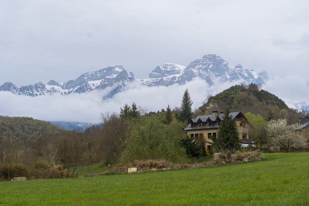 Beautiful shot of a house with foggy mountain in Panticosa