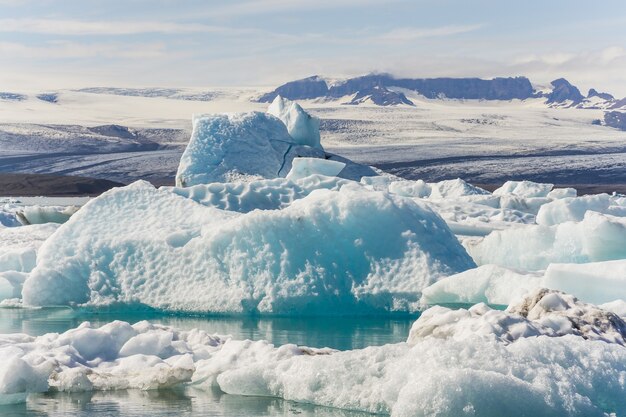 Красивый снимок айсбергов с заснеженными горами на заднем плане