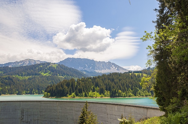 맑은 하늘 아래 산이있는 Lac de l' Hongrin 댐의 아름다운 사진-여행 블로그에 적합