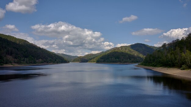 Красивый снимок озера, окруженного горами с отражением неба в воде