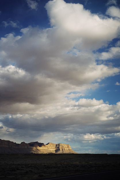 Beautiful shot of a large desert with breathtaking clouds and rocky hills