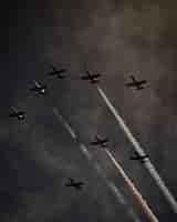 Free photo beautiful shot of many planes in the gray sky performing operations and pirouetting