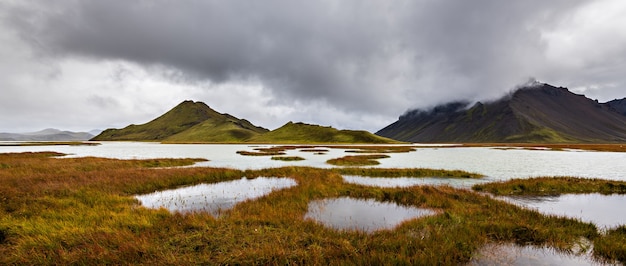 Beautiful shot of mountains in Highlands region of Iceland with a cloudy gray sky in the background