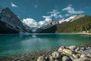 Foto gratuita bello colpo delle montagne che riflettono nel lago freddo sotto il cielo nuvoloso