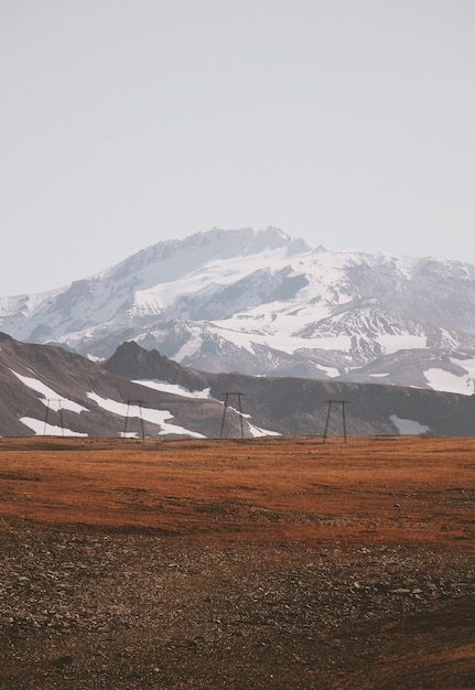 Free photo beautiful shot of a muddy field with amazing snowy mountains