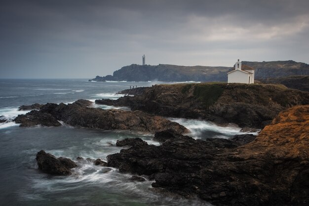 Beautiful shot of the ocean with rock formations by the shore on a cloudy day