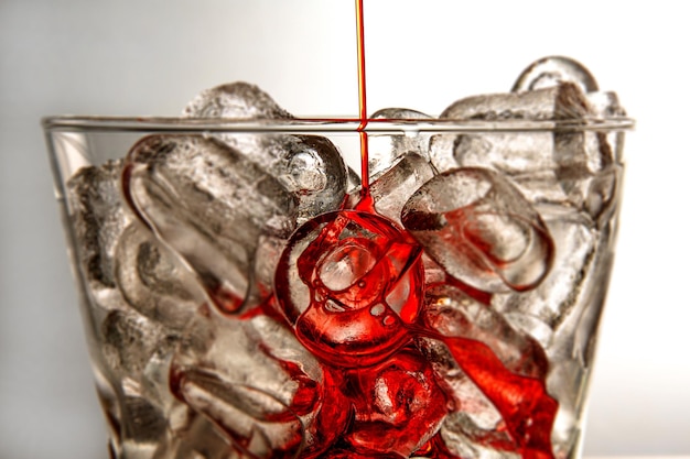 無料写真 中に赤い液体が注がれているガラスの角氷の美しいショット