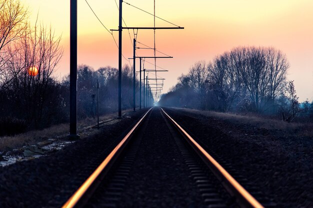 夜明けの素晴らしいピンクの空と田舎の鉄道の美しいショット